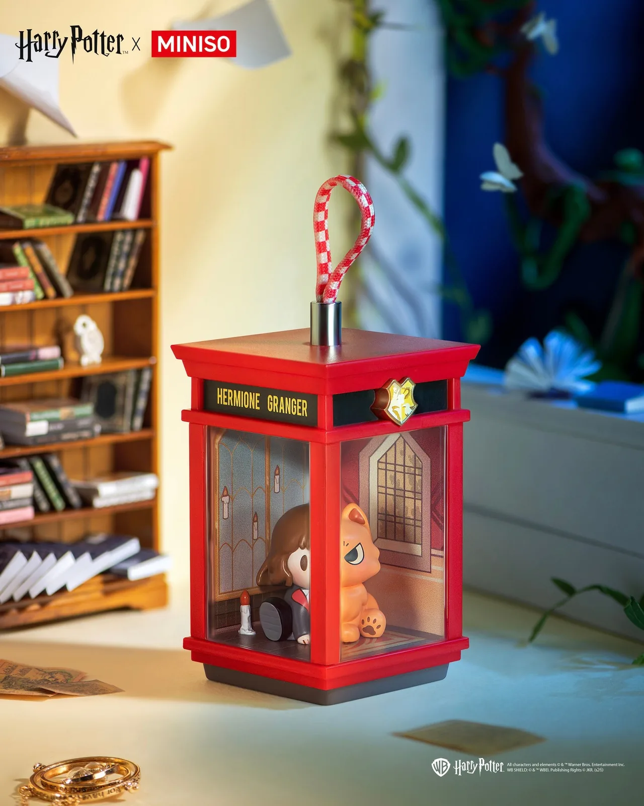 Підвіска Hermione Granger and Crookshanks MINISO Magic House на тлі книжкових полиць