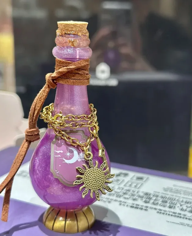 Фігурка MINISO: фіолетовий флакон з місяцем на етикетці, шкіряним шнурком і підвіскою-сонцем